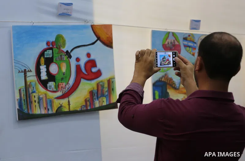 Palestinians attend the art exhibition "draw your dream for Gaza 2020", in Gaza city on Aug. 23, 2016. Photo by Mohammed Asad