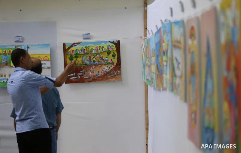 Palestinians attend the art exhibition "draw your dream for Gaza 2020", in Gaza city on Aug. 23, 2016. Photo by Mohammed Asad