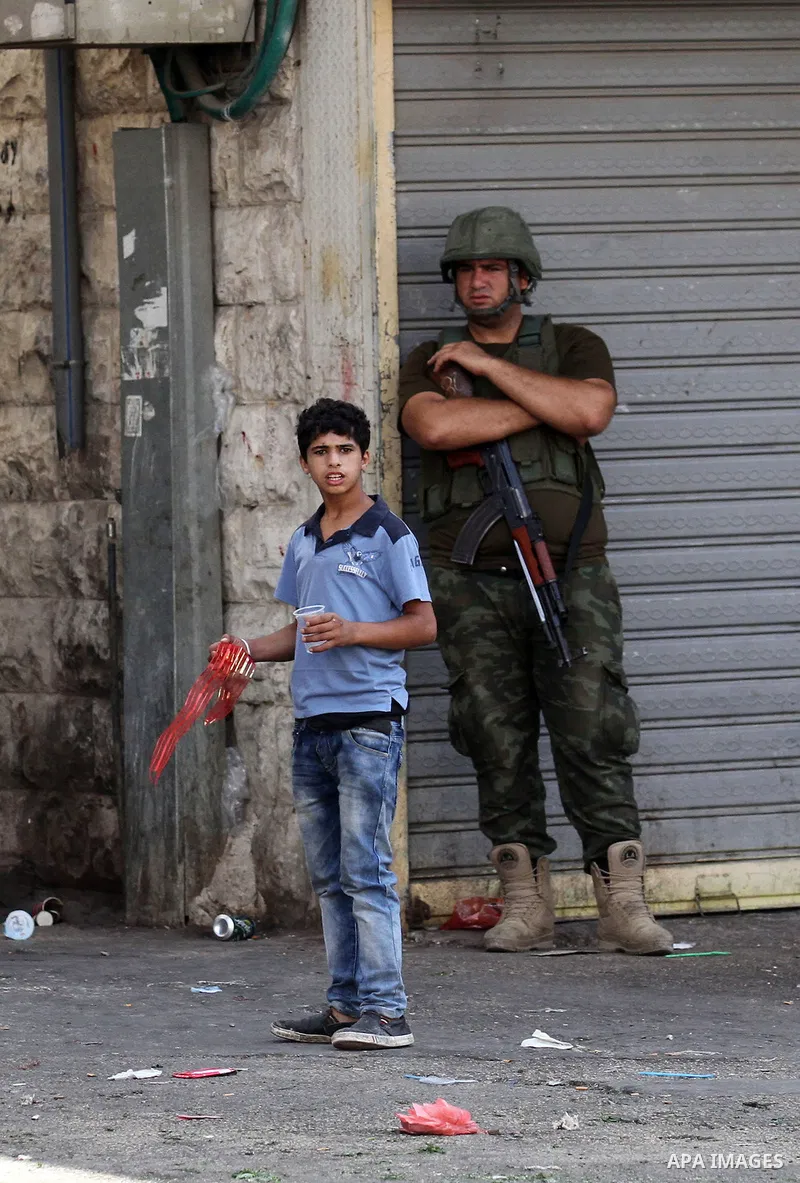 A member of Palestinian security forces stands guard following clashes with Palestinian youths in the old town of the West Bank city of Nablus August 23, 2016. Photo by Nedal Eshtayah