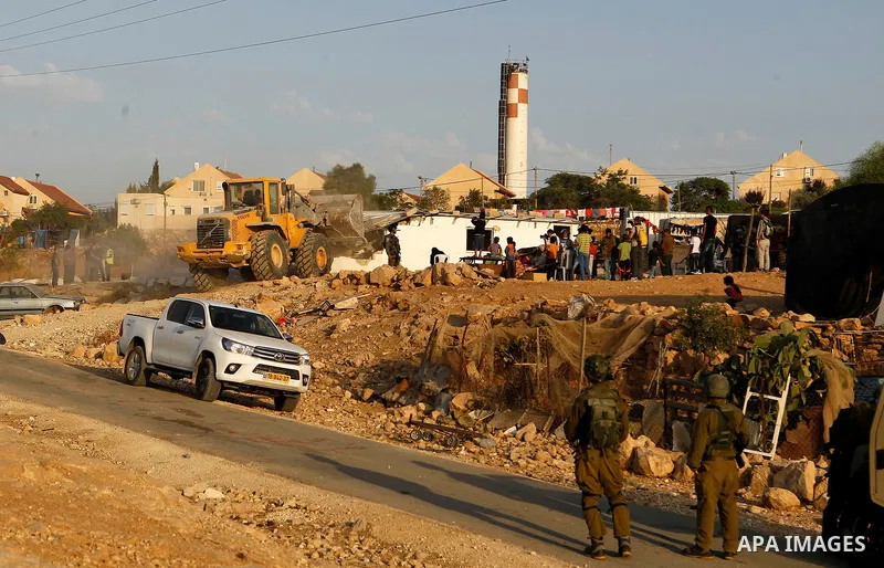 Israeli troops stand guard as bulldozers demolish houses near the West Bank village of Um AlKhair, south of Hebron August 24, 2016. Photo by Wisam Hashlamoun