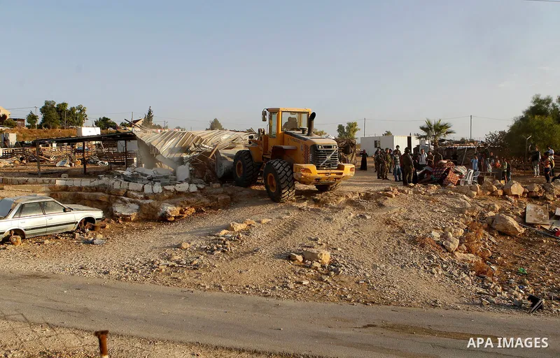 Israeli troops stand guard as bulldozers demolish houses near the West Bank village of Um AlKhair, south of Hebron August 24, 2016. Photo by Wisam Hashlamoun