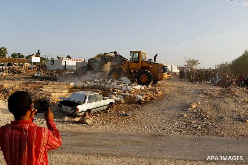 Israeli troops stand guard as bulldozers demolish houses near the West Bank village of Um AlKhair, south of Hebron August 24, 2016. Photo by Wisam Hashlamoun