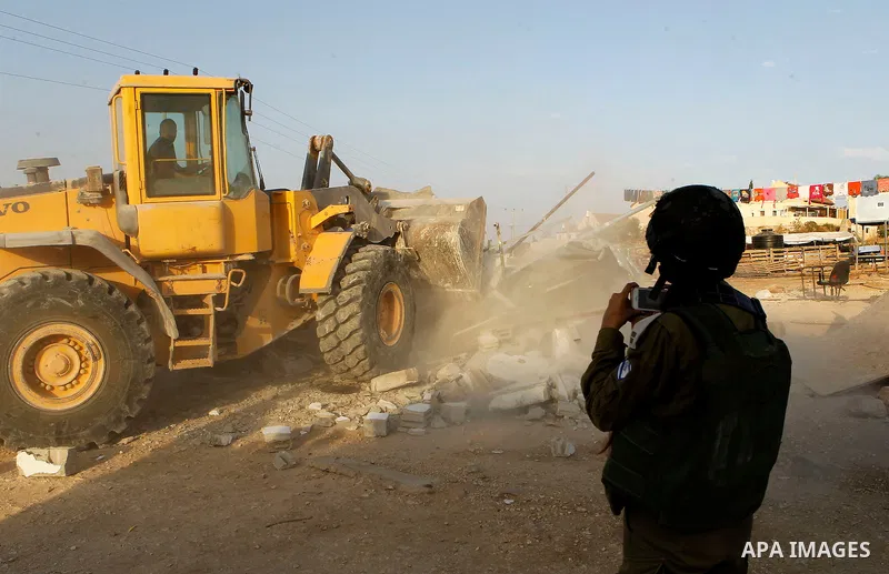 Israeli troops stand guard as bulldozers demolish houses near the West Bank village of Um AlKhair, south of Hebron August 24, 2016. Photo by Wisam Hashlamoun