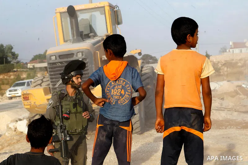 Israeli troops stand guard as bulldozers demolish houses near the West Bank village of Um AlKhair, south of Hebron August 24, 2016. Photo by Wisam Hashlamoun