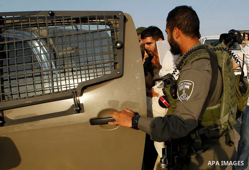 Israeli border policemen carry away a Palestinian man after Israeli troops demolished his house near the West Bank village of Um AlKhair, south of Hebron August 24, 2016. Photo by Wisam Hashlamoun