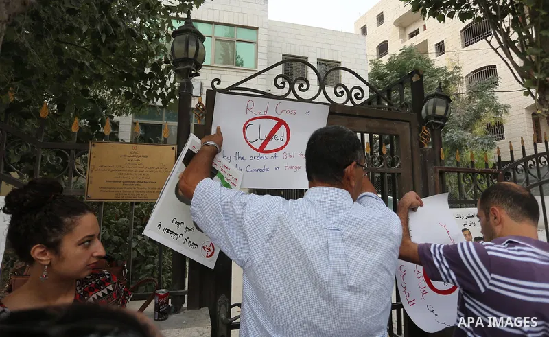 Palestinian protesters hold posters of Bilal Kayed, who stage hunger strike in Israeli jails, in front of the International Red Cross Headquarter, the West bank city of Bireh, on August 24, 2016. Photo by Shadi Hatem