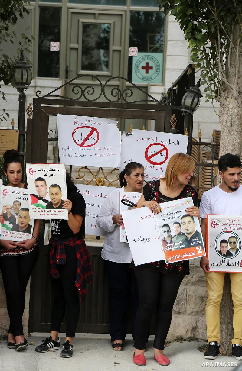 Palestinian protesters hold posters of Bilal Kayed, who stage hunger strike in Israeli jails, in front of the International Red Cross Headquarter, the West bank city of Bireh, on August 24, 2016. Photo by Shadi Hatem