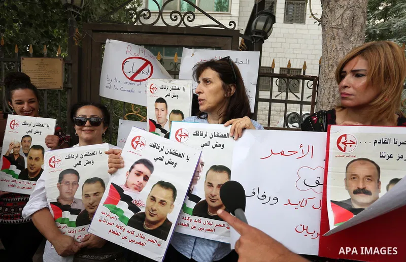 Palestinian protesters hold posters of Bilal Kayed, who stage hunger strike in Israeli jails, in front of the International Red Cross Headquarter, the West bank city of Bireh, on August 24, 2016. Photo by Shadi Hatem