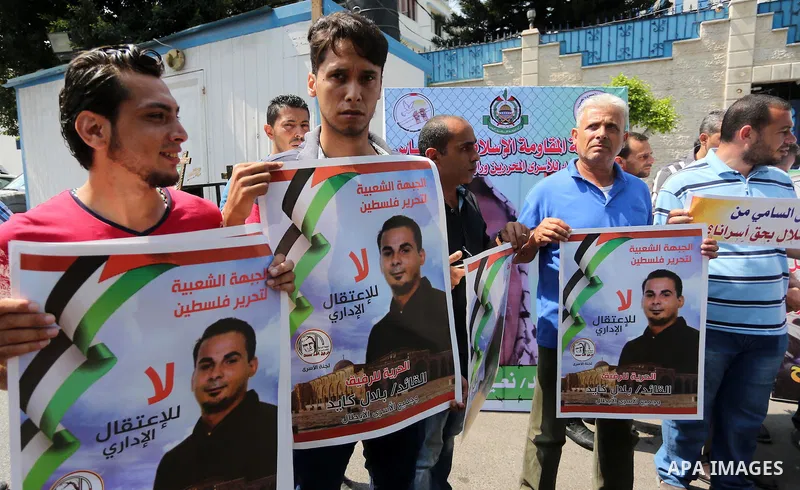 Palestinian protesters hold posters of Bilal Kayed, who stage hunger strike in Israeli jails, in front of the high commissioner for human rights headquarters in Gaza City, on Aug. 24, 2016. Photo by Mohammed Asad
