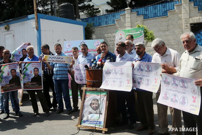 Palestinian protesters hold posters of Bilal Kayed, who stage hunger strike in Israeli jails, in front of the high commissioner for human rights headquarters in Gaza City, on Aug. 24, 2016. Photo by Mohammed Asad
