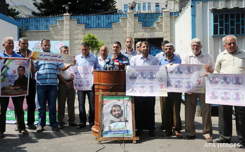 Palestinian protesters hold posters of Bilal Kayed, who stage hunger strike in Israeli jails, in front of the high commissioner for human rights headquarters in Gaza City, on Aug. 24, 2016. Photo by Mohammed Asad
