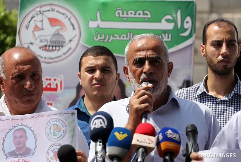 Palestinian protesters hold posters of Bilal Kayed, who stage hunger strike in Israeli jails, in front of the high commissioner for human rights headquarters in Gaza City, on Aug. 24, 2016. Photo by Mohammed Asad
