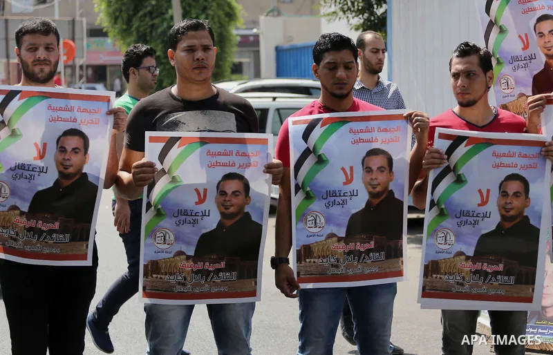 Palestinian protesters hold posters of Bilal Kayed, who stage hunger strike in Israeli jails, in front of the high commissioner for human rights headquarters in Gaza City, on Aug. 24, 2016. Photo by Mohammed Asad