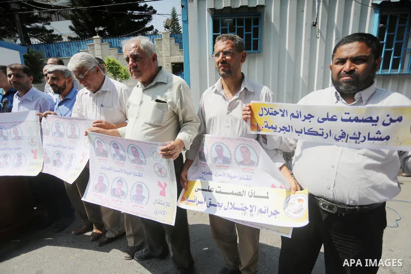 Palestinian protesters hold posters of Bilal Kayed, who stage hunger strike in Israeli jails, in front of the high commissioner for human rights headquarters in Gaza City, on Aug. 24, 2016. Photo by Mohammed Asad