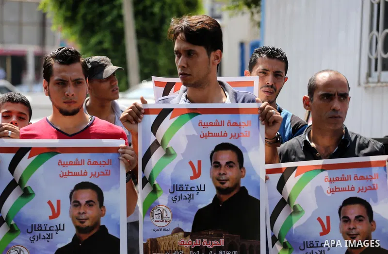 Palestinian protesters hold posters of Bilal Kayed, who stage hunger strike in Israeli jails, in front of the high commissioner for human rights headquarters in Gaza City, on Aug. 24, 2016. Photo by Mohammed Asad