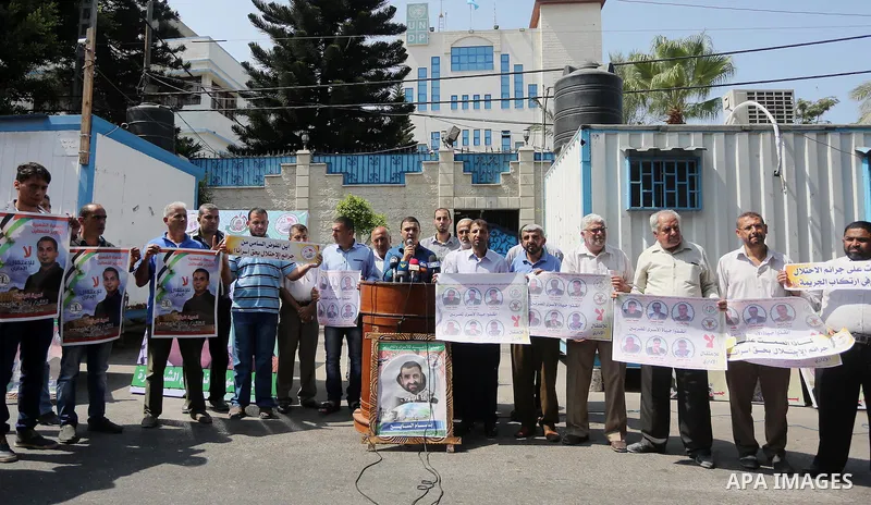 Palestinian protesters hold posters of Bilal Kayed, who stage hunger strike in Israeli jails, in front of the high commissioner for human rights headquarters in Gaza City, on Aug. 24, 2016. Photo by Mohammed Asad