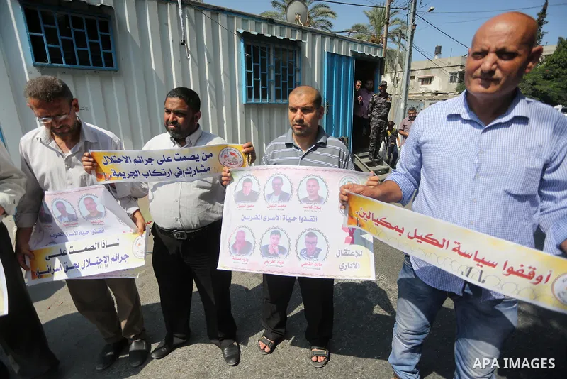 Palestinian protesters hold posters of Bilal Kayed, who stage hunger strike in Israeli jails, in front of the high commissioner for human rights headquarters in Gaza City, on Aug. 24, 2016. Photo by Mohammed Asad