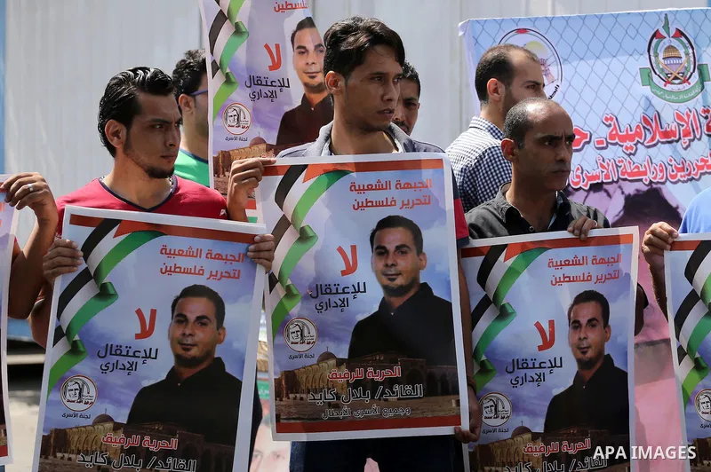 Palestinian protesters hold posters of Bilal Kayed, who stage hunger strike in Israeli jails, in front of the high commissioner for human rights headquarters in Gaza City, on Aug. 24, 2016. Photo by Mohammed Asad
