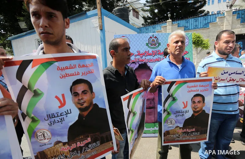 Palestinian protesters hold posters of Bilal Kayed, who stage hunger strike in Israeli jails, in front of the high commissioner for human rights headquarters in Gaza City, on Aug. 24, 2016. Photo by Mohammed Asad