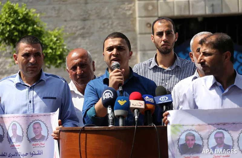 Palestinian protesters hold posters of Bilal Kayed, who stage hunger strike in Israeli jails, in front of the high commissioner for human rights headquarters in Gaza City, on Aug. 24, 2016. Photo by Mohammed Asad