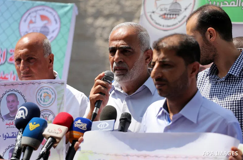 Palestinian protesters hold posters of Bilal Kayed, who stage hunger strike in Israeli jails, in front of the high commissioner for human rights headquarters in Gaza City, on Aug. 24, 2016. Photo by Mohammed Asad
