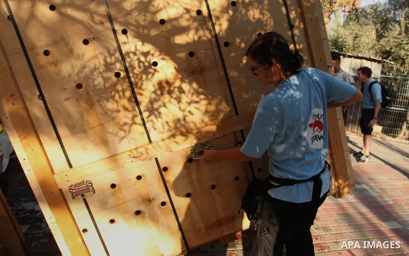 Members of the international animal welfare charity "Four Paws" clean cages at a zoo in Khan Yunis, in the southern Gaza Strip, prior to evacuating all the animals at the zoo out of the Palestinian enclave on Aug. 23, 20...