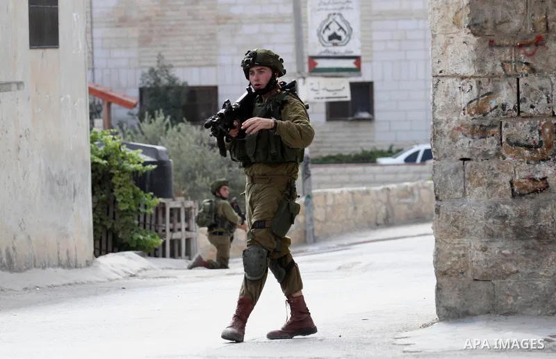 An Israeli soldier conducts a search near the scene where Palestinian Sari Abu Ghrab was shot dead by Israeli troops near the West Bank village of Madama near Nablus August 24, 2016. An Israeli army statement said Israel...
