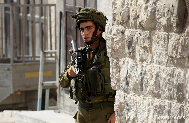 An Israeli soldier conducts a search near the scene where Palestinian Sari Abu Ghrab was shot dead by Israeli troops near the West Bank village of Madama near Nablus August 24, 2016. An Israeli army statement said Israel...