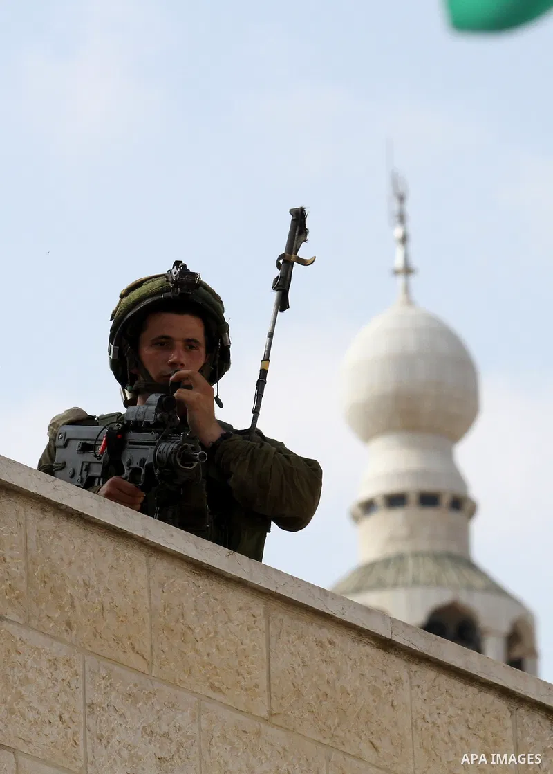 An Israeli soldier conducts a search near the scene where Palestinian Sari Abu Ghrab was shot dead by Israeli troops near the West Bank village of Madama near Nablus August 24, 2016. An Israeli army statement said Israel...