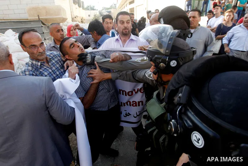 Israeli border policemen push a Palestinian demonstrator during a protest calling for the reopening of a closed street in the West Bank city of Hebron August 24, 2016. Photo by Wisam Hashlamoun