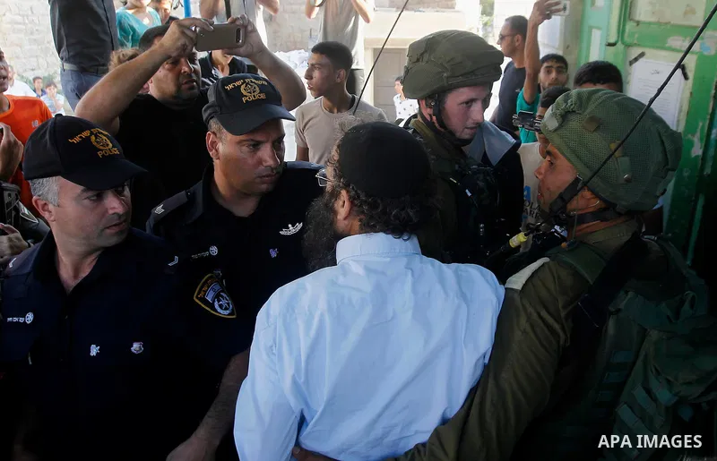 A Jewish settler argues with Israeli policemen during a protest by Palestinians calling for the reopening of a closed street in the West Bank city of Hebron August 24, 2016. Photo by Wisam Hashlamoun
