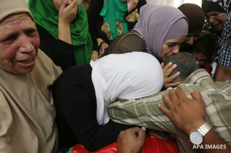 Relatives of Palestinian man Eyad Hamed who was shot and killed by Israeli forces on Friday, mourn around his body during his funeral in the West Bank village of Silwad near Ramallah August 26, 2016. Photo by Shadi Hatem