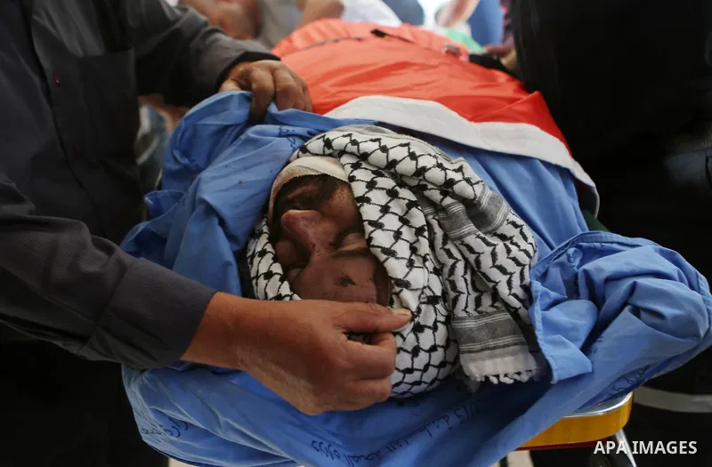 Relatives of Palestinian man Eyad Hamed who was shot and killed by Israeli forces on Friday, mourn around his body during his funeral in the West Bank village of Silwad near Ramallah August 26, 2016. Photo by Shadi Hatem