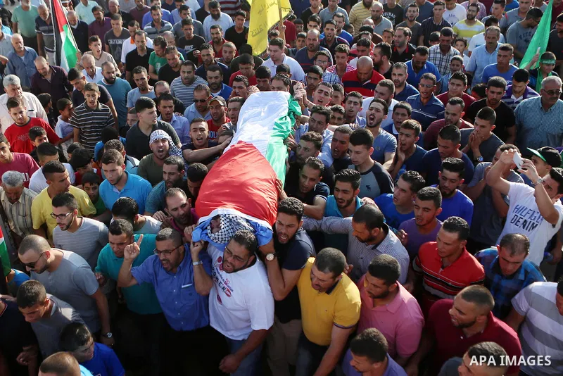 Mourners carry the body of Palestinian man Eyad Hamed, who was shot and killed by Israeli forces on Friday, during his funeral in the West Bank village of Silwad near Ramallah August 26, 2016. Photo by Shadi Hatem
