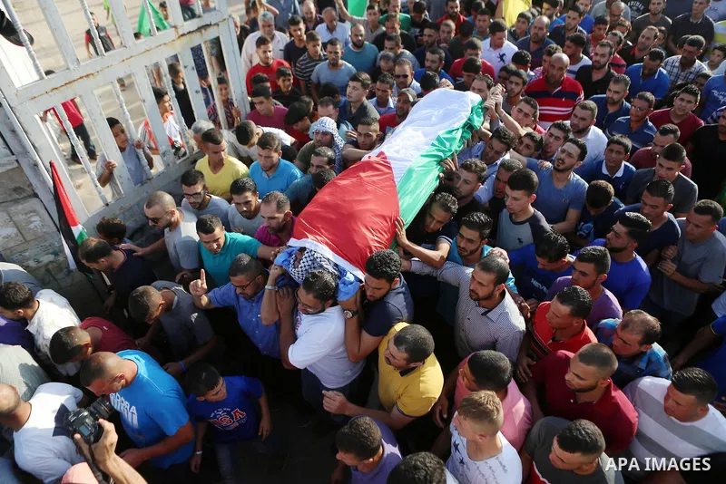 Mourners carry the body of Palestinian man Eyad Hamed, who was shot and killed by Israeli forces on Friday, during his funeral in the West Bank village of Silwad near Ramallah August 26, 2016. Photo by Shadi Hatem