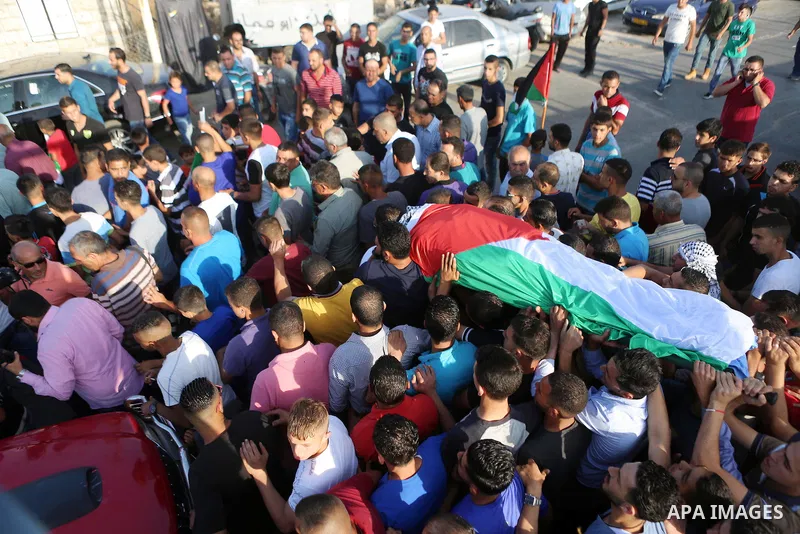 Mourners carry the body of Palestinian man Eyad Hamed, who was shot and killed by Israeli forces on Friday, during his funeral in the West Bank village of Silwad near Ramallah August 26, 2016. Photo by Shadi Hatem