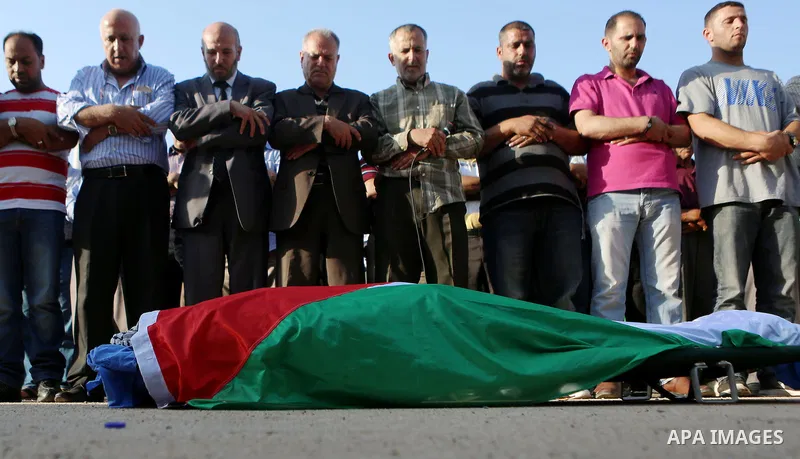 Mourners pray in front of the body of Palestinian man Eyad Hamed, who was shot and killed by Israeli forces on Friday, during his funeral in the West Bank village of Silwad near Ramallah August 26, 2016. Photo by Shadi H...