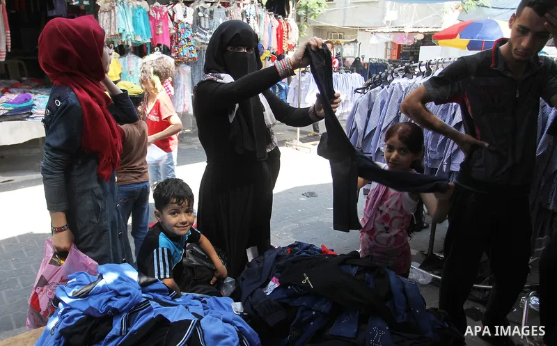 Palestinians shop during preparation for the new school year at a market in Rafah in the southern Gaza strip on August 27, 2016. Photo by Abed Rahim Khatib