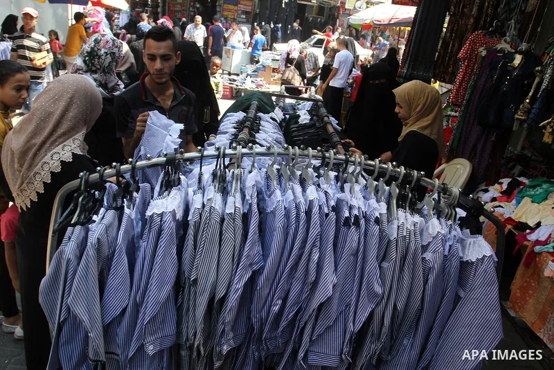 Palestinians shop during preparation for the new school year at a market in Rafah in the southern Gaza strip on August 27, 2016. Photo by Abed Rahim Khatib