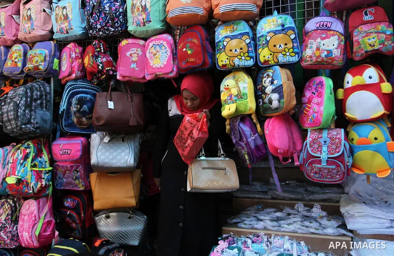 Palestinians shop during preparation for the new school year at a market in Rafah in the southern Gaza strip on August 27, 2016. Photo by Abed Rahim Khatib