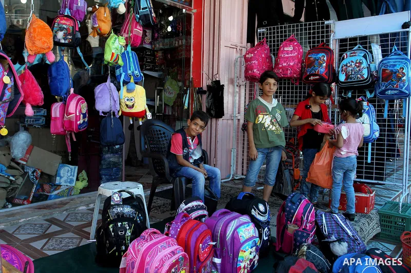 Palestinians shop during preparation for the new school year at a market in Rafah in the southern Gaza strip on August 27, 2016. Photo by Abed Rahim Khatib