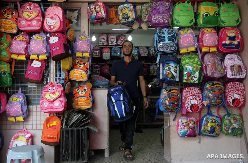 Palestinians shop during preparation for the new school year at a market in Rafah in the southern Gaza strip on August 27, 2016. Photo by Abed Rahim Khatib