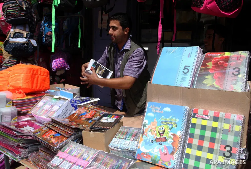 Palestinians shop during preparation for the new school year at a market in Rafah in the southern Gaza strip on August 27, 2016. Photo by Abed Rahim Khatib