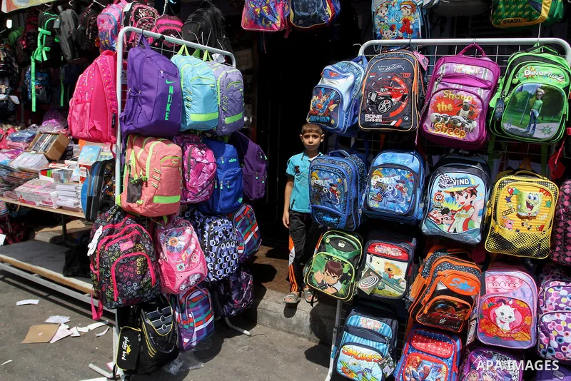Palestinians shop during preparation for the new school year at a market in Rafah in the southern Gaza strip on August 27, 2016. Photo by Abed Rahim Khatib