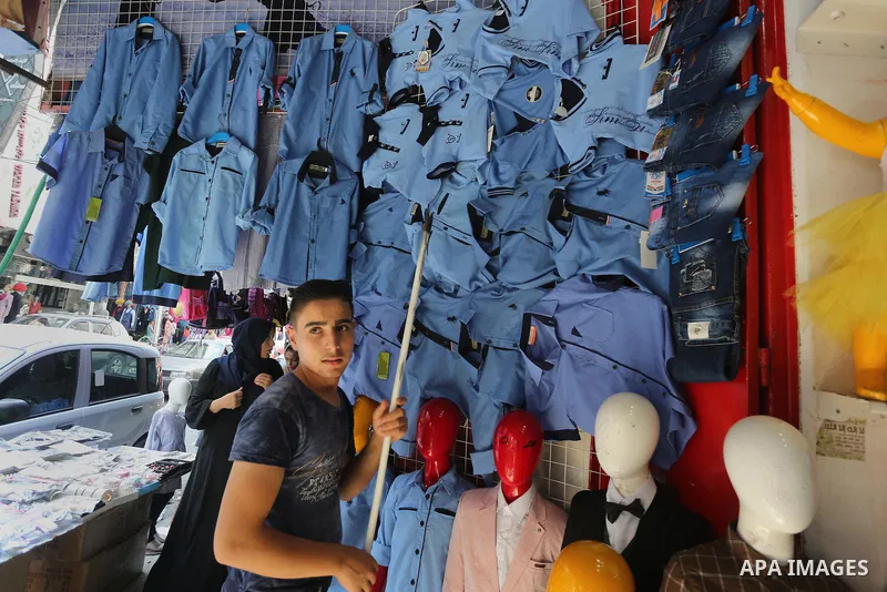 Palestinians shop during preparation for the new school year at a market in Gaza city, on August 27, 2016. Photo by Mohammed Asad