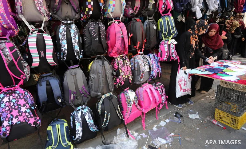 Palestinians shop during preparation for the new school year at a market in Gaza city, on August 27, 2016. Photo by Mohammed Asad