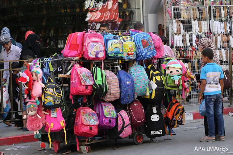 Palestinians shop during preparation for the new school year at a market in Gaza city, on August 27, 2016. Photo by Mohammed Asad
