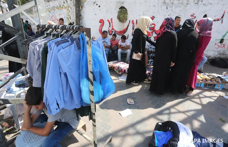 Palestinians shop during preparation for the new school year at a market in Gaza city, on August 27, 2016. Photo by Mohammed Asad