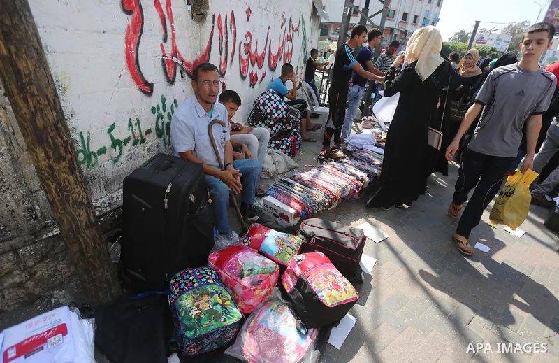 Palestinians shop during preparation for the new school year at a market in Gaza city, on August 27, 2016. Photo by Mohammed Asad
