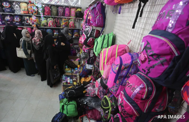 Palestinians shop during preparation for the new school year at a market in Gaza city, on August 27, 2016. Photo by Mohammed Asad